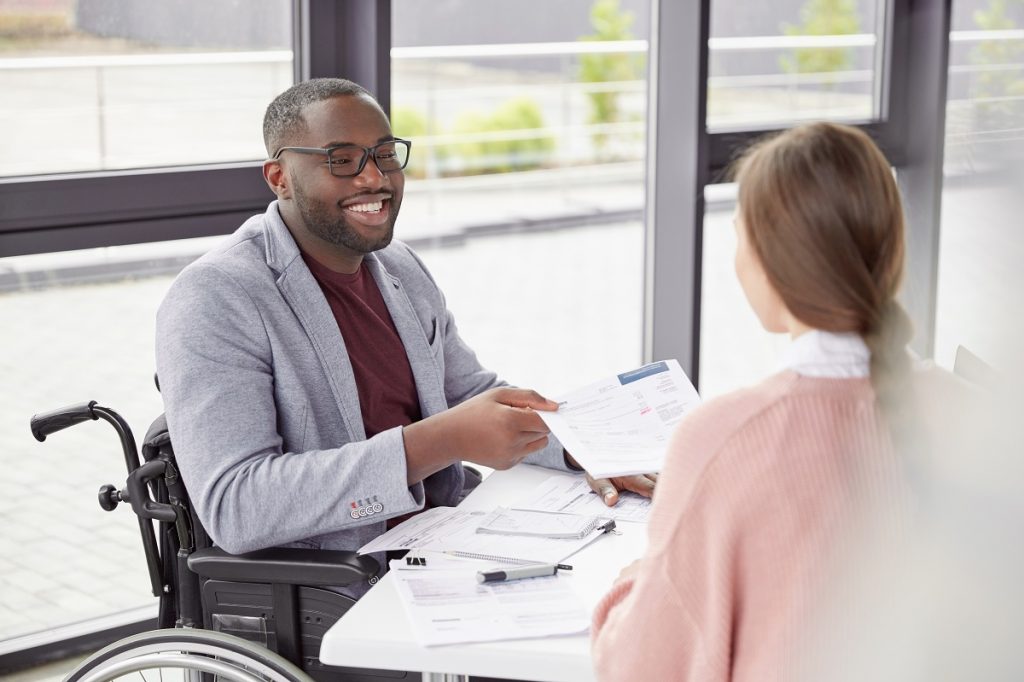 African American male sits at workplace in wheelchair